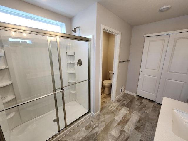 bathroom with sink, wood-type flooring, toilet, and a shower with door