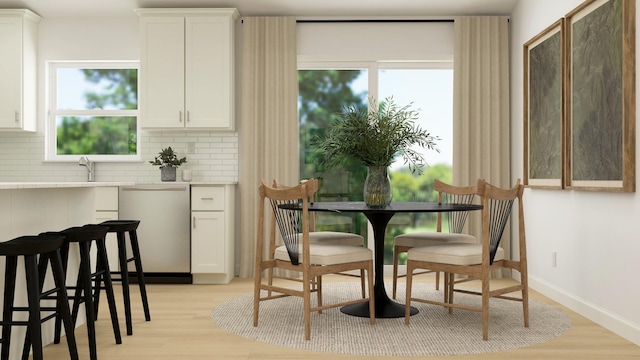 dining area with sink and light hardwood / wood-style flooring