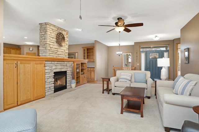 carpeted living room with ceiling fan and a fireplace