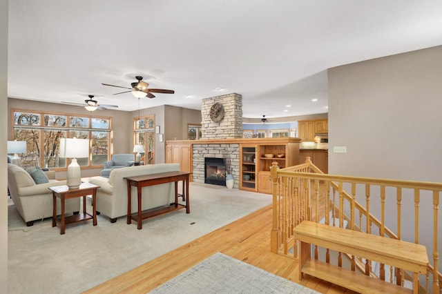 living room with a stone fireplace and light hardwood / wood-style flooring