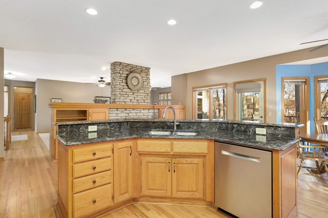 kitchen featuring sink, dishwasher, an island with sink, and light hardwood / wood-style flooring