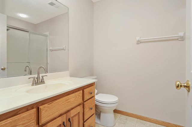 bathroom with vanity, a shower with shower door, and toilet