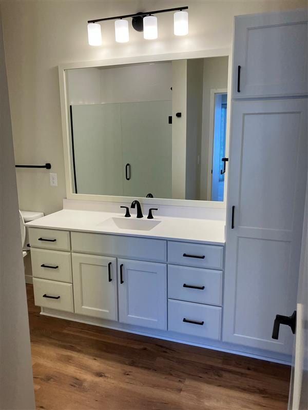 bathroom featuring vanity, toilet, and hardwood / wood-style floors