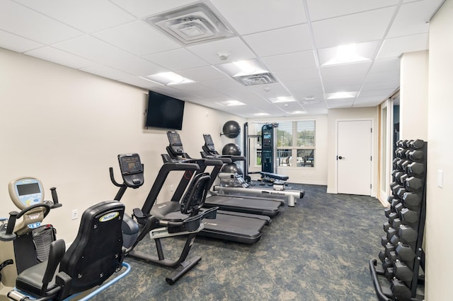 workout area featuring a drop ceiling and dark carpet