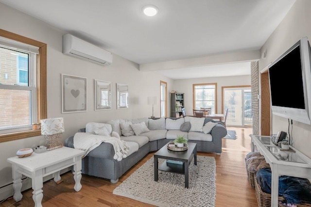 living area with light wood-style flooring, a baseboard heating unit, and a wall unit AC