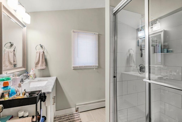 bathroom with a stall shower, vanity, baseboards, and a baseboard radiator