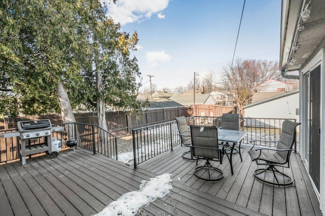 wooden deck featuring a fenced backyard, a grill, and outdoor dining space