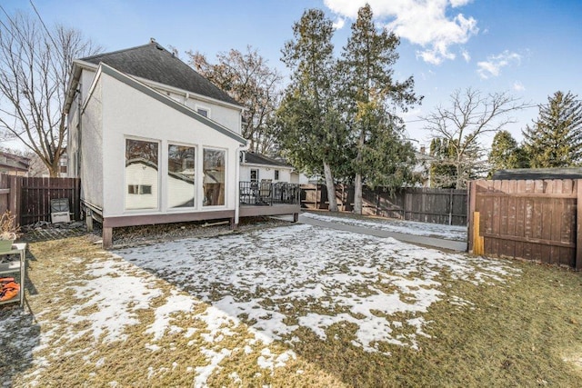 back of house with a deck, a fenced backyard, and stucco siding