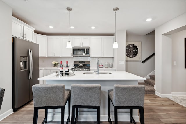 kitchen with white cabinetry, stainless steel appliances, and hanging light fixtures