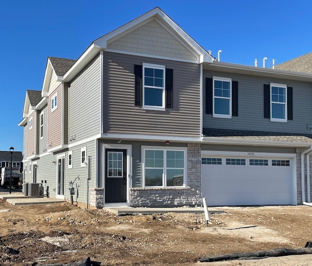 view of front of house featuring a garage and central air condition unit