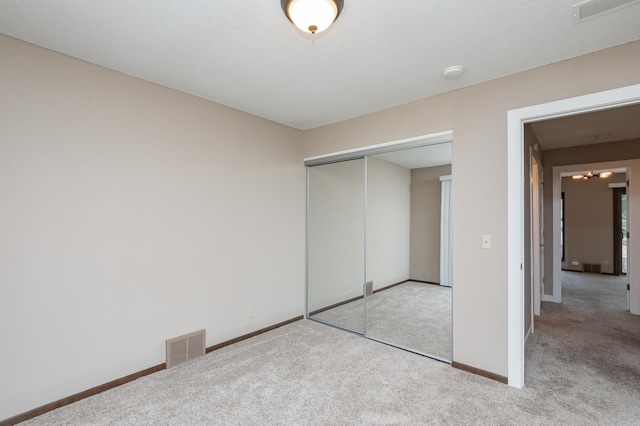 unfurnished bedroom featuring a closet and light carpet