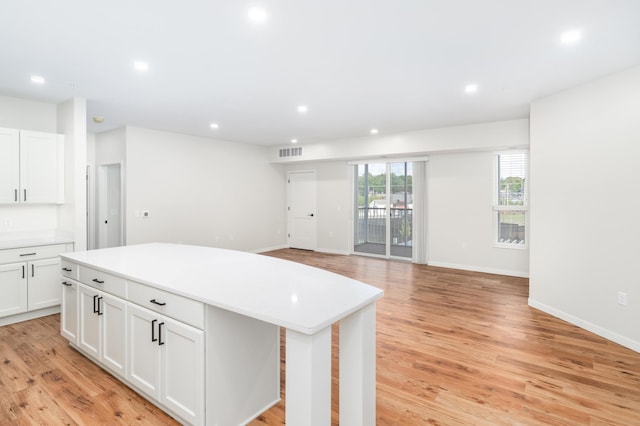 kitchen featuring white cabinetry, a center island, and light wood-type flooring