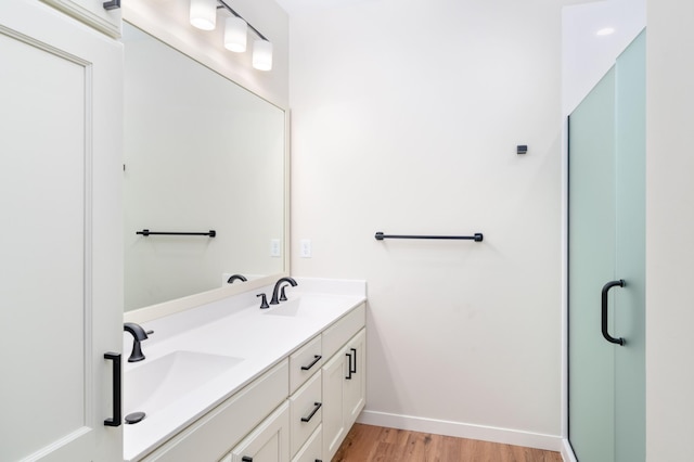 bathroom with vanity, hardwood / wood-style floors, and a shower with shower door