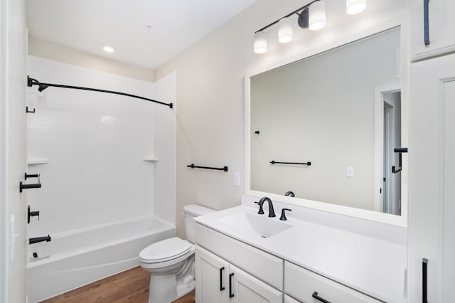 full bathroom featuring hardwood / wood-style flooring, shower / bathtub combination, vanity, and toilet