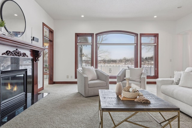 carpeted living room with a tiled fireplace