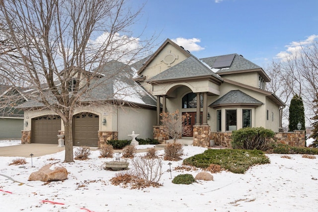 view of front of property with a garage and solar panels