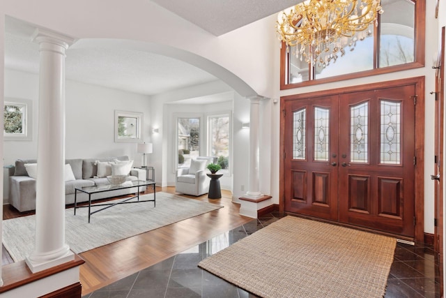 tiled foyer entrance featuring decorative columns and a high ceiling