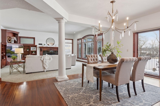 dining room featuring a wealth of natural light, light wood-type flooring, and ornate columns