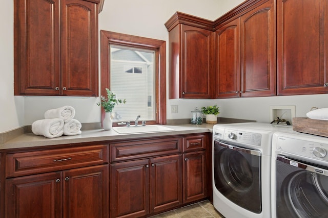 washroom with sink, washing machine and dryer, cabinets, and light tile patterned flooring