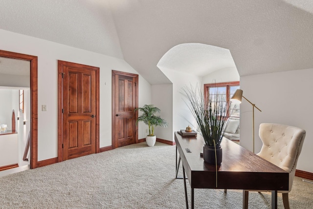 office area with lofted ceiling, carpet floors, and a textured ceiling