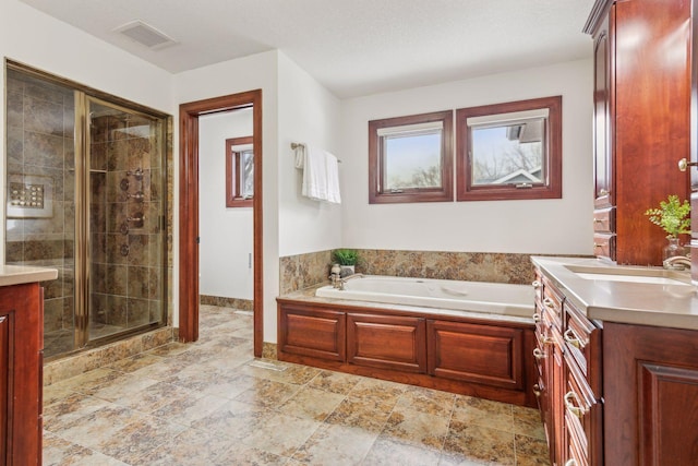 bathroom featuring vanity and independent shower and bath