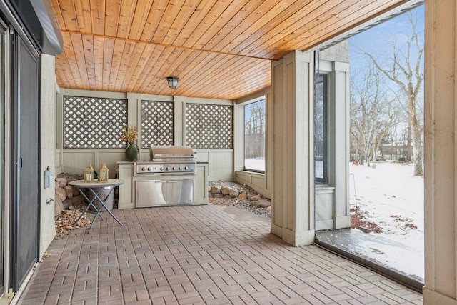 snow covered patio with an outdoor kitchen and grilling area