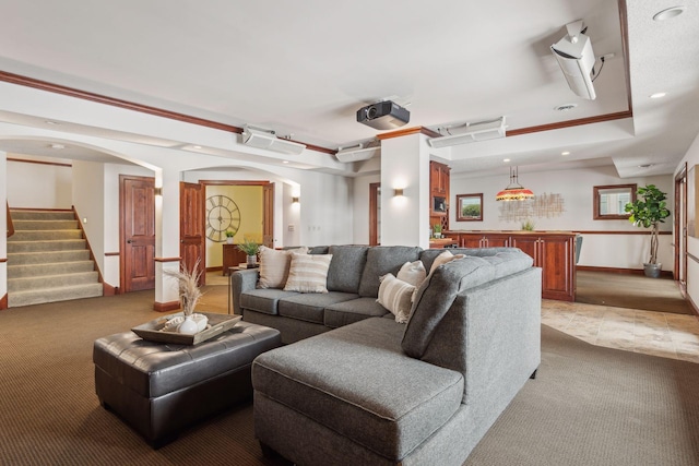 carpeted living room featuring ornamental molding and a raised ceiling