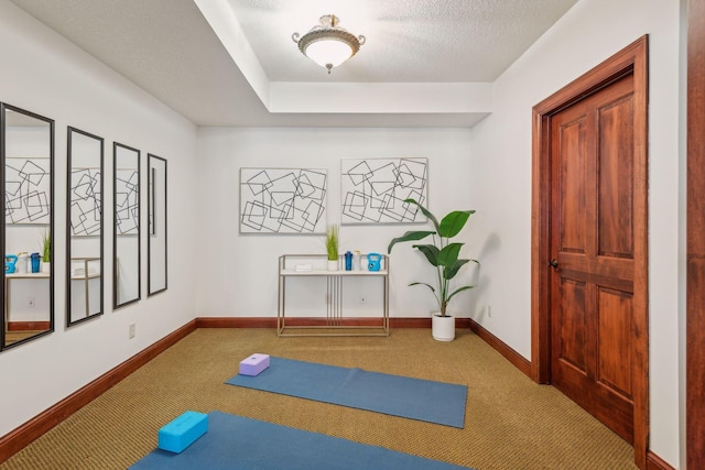 exercise room featuring carpet and a textured ceiling