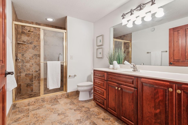 bathroom with vanity, an enclosed shower, a textured ceiling, and toilet