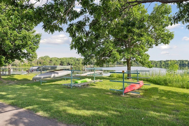 view of home's community with a water view and a lawn