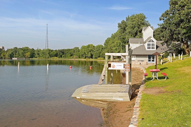 dock area with a water view and a yard