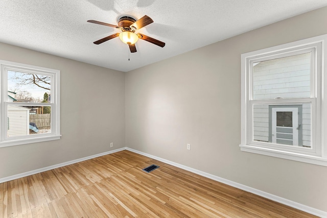 unfurnished room with ceiling fan, light hardwood / wood-style floors, and a textured ceiling