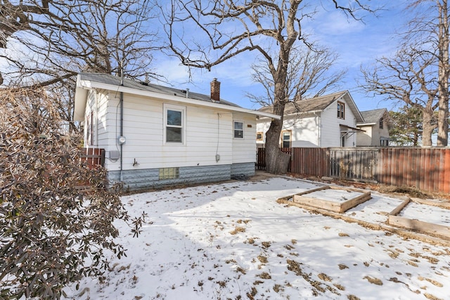 view of snow covered rear of property