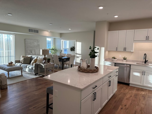 kitchen with dark wood-type flooring, sink, white cabinetry, a center island, and dishwasher