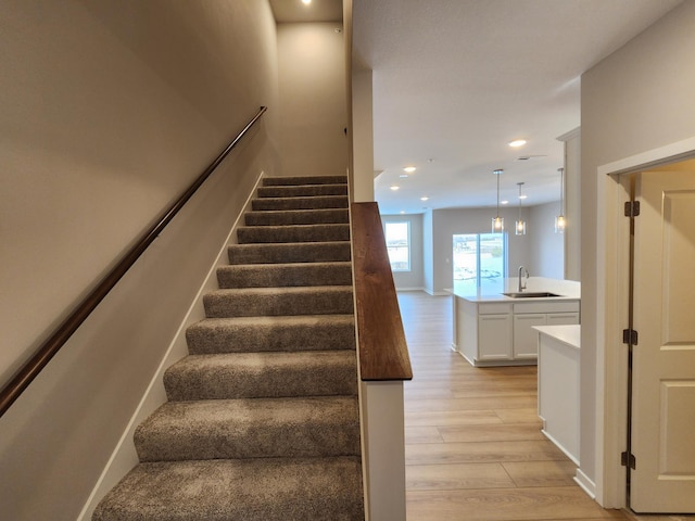 stairs featuring sink and hardwood / wood-style flooring