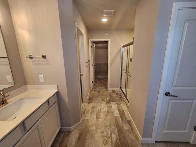 bathroom with vanity, a shower with door, and hardwood / wood-style floors