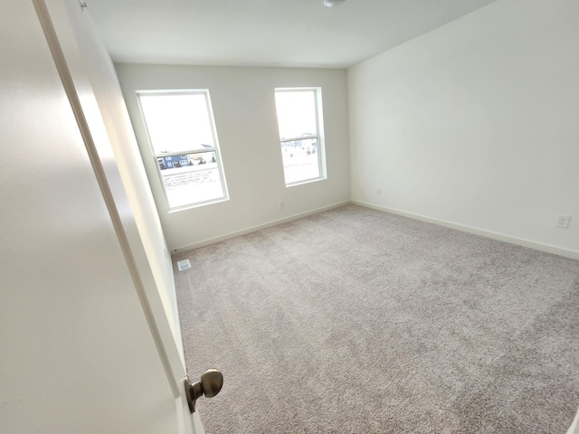 spare room featuring light colored carpet