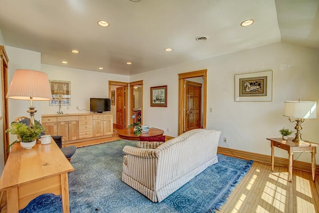 living area with recessed lighting, baseboards, and wood finished floors