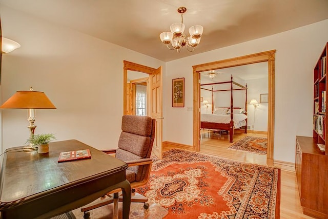 home office with an inviting chandelier, baseboards, and light wood-type flooring