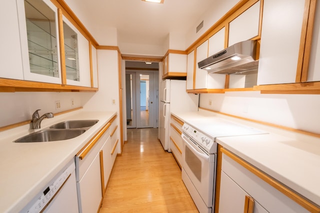 kitchen featuring sink, white appliances, light wood-type flooring, and white cabinets