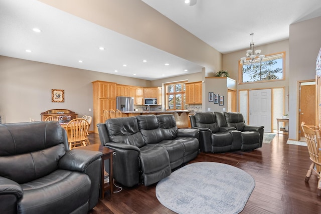 living room with a high ceiling, dark wood-type flooring, and a notable chandelier