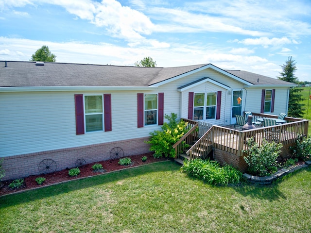 view of front facade with a deck and a front yard