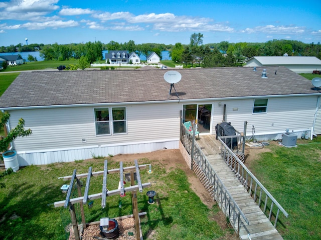 rear view of property with a wooden deck and a lawn