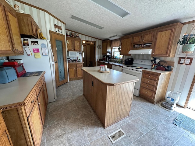 kitchen with a textured ceiling, a kitchen island, lofted ceiling, and white appliances