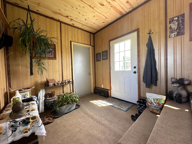 doorway to outside with carpet, crown molding, wood walls, and wooden ceiling