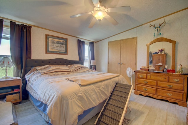 bedroom with ceiling fan, a closet, crown molding, and vaulted ceiling