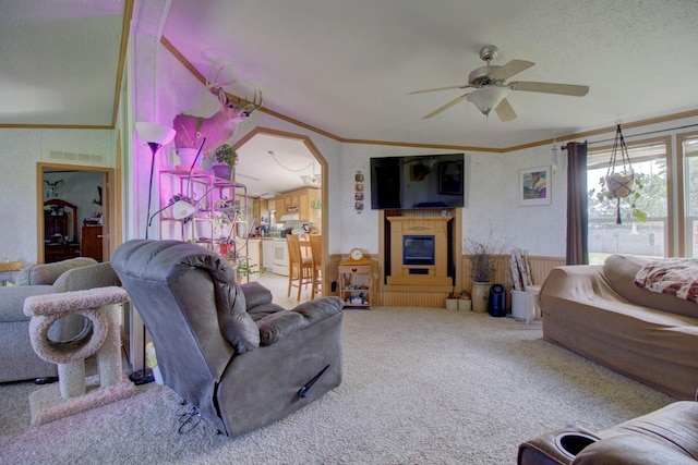 living room featuring carpet, vaulted ceiling, crown molding, and ceiling fan