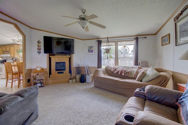 carpeted living room featuring ceiling fan, a textured ceiling, and ornamental molding