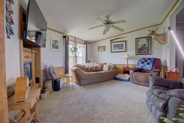 carpeted living room with ceiling fan, a textured ceiling, ornamental molding, and vaulted ceiling