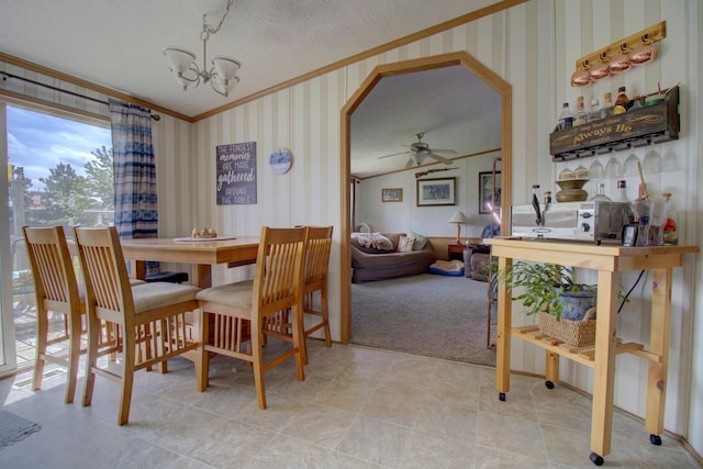 dining space featuring ceiling fan with notable chandelier, a textured ceiling, lofted ceiling, carpet flooring, and crown molding